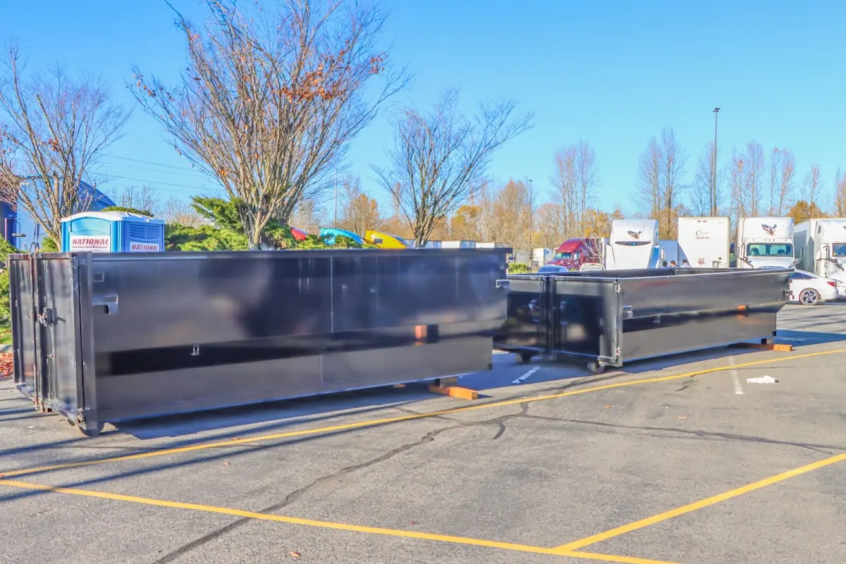 Professional dumpster rental service with roll-off container on residential driveway in Needham